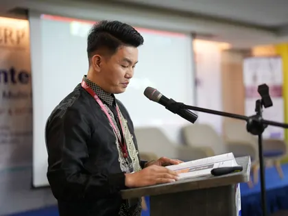 A presenter reading from the podium